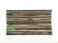Stack of vinyl LP records viewed from top, showing spines with artist and album titles.