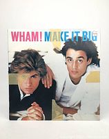 Front cover of Wham! Make It Big vinyl album with two members posing, visible tape marks on cover.