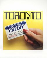 Front cover of the Toronto 12-inch LP showing a hand holding a credit card with the band name.