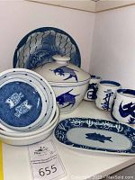 Photo of entire set showing soup bowl with lid, serving platter, bowls, and ceramic cups in blue and white fish design.