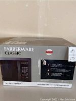 Front box view showing Farberware Classic branding and product image of microwave with keypad and digital display.