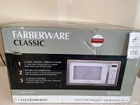 Closed box of Farberware Classic microwave oven showing front with brand logo, model details, and features.