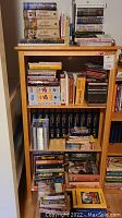 Full bookshelf showing all books, DVDs and CDs arranged on three shelves