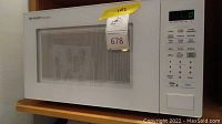 Sharp Carousel microwave showing full front and side view on shelf, white exterior.