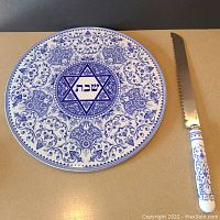 Full view of round cake plate showing detailed blue floral pattern and central Star of David with Hebrew text.