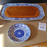 Challah platter and round scalloped dish with blue and white designs on a counter.