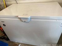 Front, closed lid view of white chest freezer