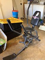 Full front view of the Cardio Cruiser Plus exerciser showing pedals, seat, and handles in a garage setting.