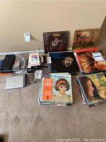 Photo showing vinyl record albums, VHS tapes, micro and cassette tapes laid on floor near wall