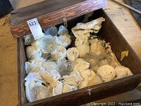 Wooden crate filled with carefully wrapped vintage glass cups secured in paper.