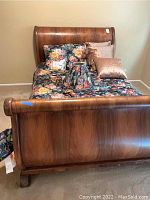 Full view of the vintage full size wooden sleigh bed showing headboard, footboard, and bedding.