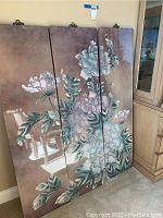 Three vertical panels showing floral painting with flowers and leaves in blue, green, and brown tones.