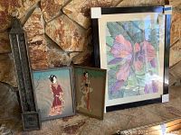Photo showing the large framed flower watercolor painting, two smaller framed Asian prints, and the tall metal thermometer against a stone wall.