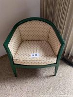 Full view of the green frame accent chair with floral cushioned upholstery.