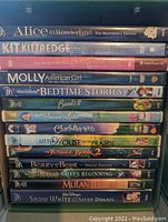 Stack of 14 DVDs showing titles and cases, featuring a mix of Disney movies and American Girl titles.