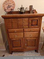Front view of oak apothecary cabinet showing 10 small upper drawers, 2 mid-size drawers and 2 lower cabinet doors