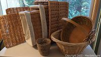 Photo showing several wicker baskets, including large rectangular basket, smaller baskets with fabric liners, and small round basket.