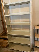 Front view of a tall Ikea Leksvik bookcase with six shelves showing light celery green painted solid wood, slightly dirty condition