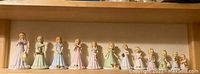 Eleven Enesco Birthday Girl figurines lined up in order by age from 1 to 12
