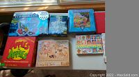 Photo of eight kids board games and puzzles, including Magnetix, Candy Land, Apples to Apples, Lewis & Clark puzzle, I Never Forget a Face, Guess Who, Glow in the Dark puzzle, and Monopoly Jr.