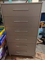 Front view of six-drawer grey dresser with horizontal metal handles