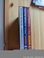 Side view of three Soccer Secrets & Fitness DVDs showing Intermediate, Advanced, and Beginner levels.