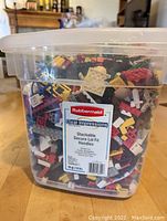 Clear Rubbermaid 19 quart storage bin filled with assorted Lego bricks in various colors and shapes