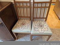 Full view of two wooden antique dining chairs side by side showing backs and seats.