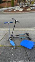 Shows a blue fun board and two three-wheeled scooters, one with blue deck and another with black dual footboards.