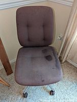 Single view of the Steelcase office chair showing the seat and backrest with water discoloration and the metal base with caster wheels.