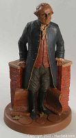 Full view of the George Washington ceramic figurine showing detailed colonial attire and brick wall base.