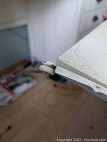 Close-up of the damaged drawer glide requiring replacement.