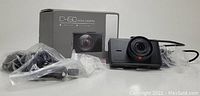 Apeman C450 dash camera, its box, and included accessories all in plastic bags laid out on a surface.
