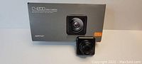 Photo of Apeman C420D dash camera in front of its original box