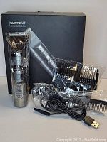 Suprent hair clipper set displayed with the main clipper unit, comb attachments, USB charging cable, cleaning brush, and original black packaging box.