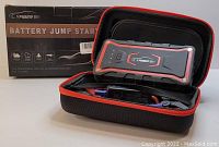 Photo of Yaber battery jump starter device, carrying case, charging cable and clamps, along with the product box in background.