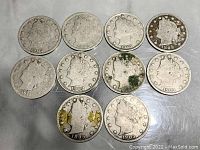 Top-down view of ten Liberty Head nickels arranged in two rows showing front facial profiles and star borders, varying tarnish and wear visible.