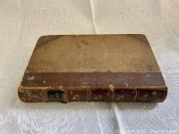 Top front cover view of the book showing half leather and cloth binding with signs of age and wear.