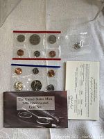 Photo showing full contents of the lot: two plastic pouches with uncirculated 1996 coins from two mints and separate 50th Anniversary Roosevelt Dime along with Certificate of Authenticity and folder.