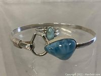 Close-up of sterling silver bracelet with triangular Larimar stone and reversible ring with smaller Larimar stone.