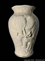 Front view of ivory ceramic vase with embossed adult and baby elephants, foliage design with glossy finish.
