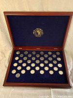Full open display case showing 40 quarters in capsules arranged in 5 rows on blue velvet.