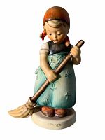 Front and side view of the figurine showing detailed hand-painted features, broom, and clothing.