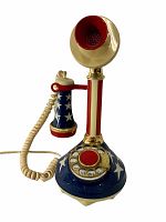 Front view of the vintage candlestick telephone showing the patriotic red, white, and blue color scheme with stars, gold mouthpiece, and rotary dial.