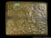 Front side of wallet showing detailed embossed decorative pattern with signs of green oxidation.