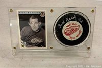Front view of the clear acrylic display case containing the signed Detroit Red Wings hockey puck and the 1992 Bill Gadsby hockey card side by side.
