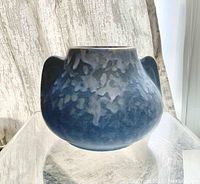 Front side view of blue drip glazed vase showing bulbous form and handles