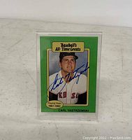 Front of the Carl Yastrzemski signed baseball card showing player photo, signature in blue ink, and green bordered design including title Baseball's All-Time Greats and playing years.
