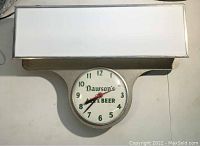 Front view of vintage light-up marquee clock with Dawson's Ale & Beer branding, showing clock face and white rectangular light panel.