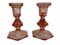 Front view of the pair of pink depression glass candle holders on a white background.